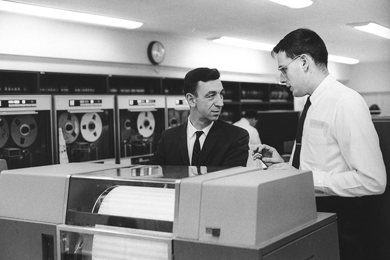 The late Prof. John Bishop (left) and Warren McFarlan '59, MBA '61, DBA '65, Baker Foundation Professor and Albert H. Gordon Professor of Business Administration, Emeritus (right) in a computer lab at Harvard Business School, ca. 1970. Bishop, a mathematician by training, was the University's first director of the Office for Information Technology and encouraged the use of computer technologies throughout Harvard. McFarlan's research has been essential to the development of corporate information systems. --© Ivan Massar, courtesy of the HBS Archives Photograph Collection: Faculty and Staff, Baker Library, Harvard Business School (olvwork390917).