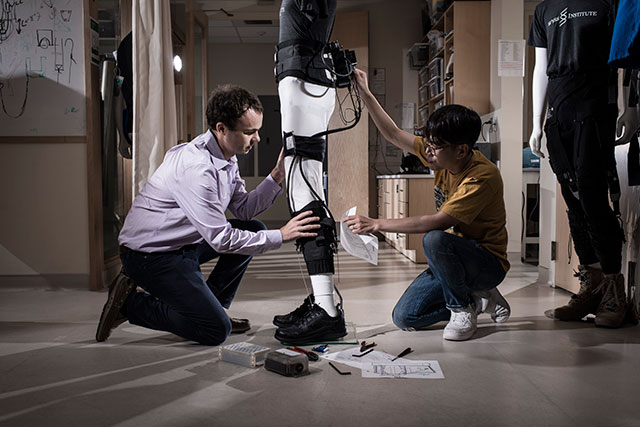 Conor Walsh and his Graduate Student Jaehyun Bae fine-tuning an ankle-assisting exosuit. Credit: Rolex Awards/Fred Merz