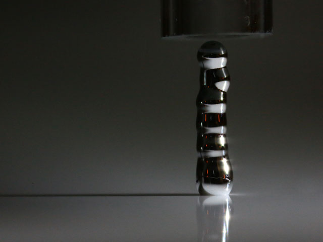 To eject droplets, acoustophoretic printing utilizes airborne ultrasounds - virtually material independent. Even liquid metal can be easily printed! This particular liquid metal forms a solid shell when in contact with the atmosphere, and this particular property makes it easy to pile drops one on top of another.