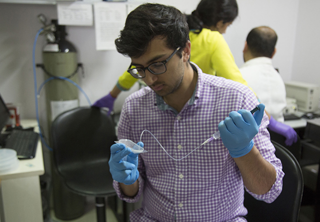 Neil Davey examines the team’s microfluidic device at the Indian Institute of Technology lab in Bombay. (Photo courtesy of Neil Davey) 