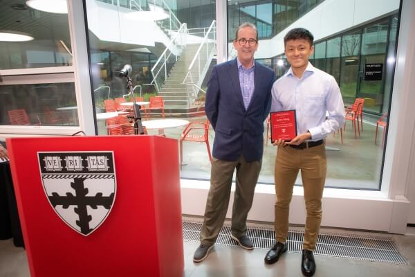 Dean Doyle and Jaylen Wang, who is holding a plaque 