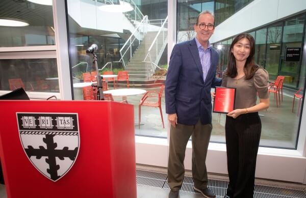 Esther Koh holding plaque with Dean