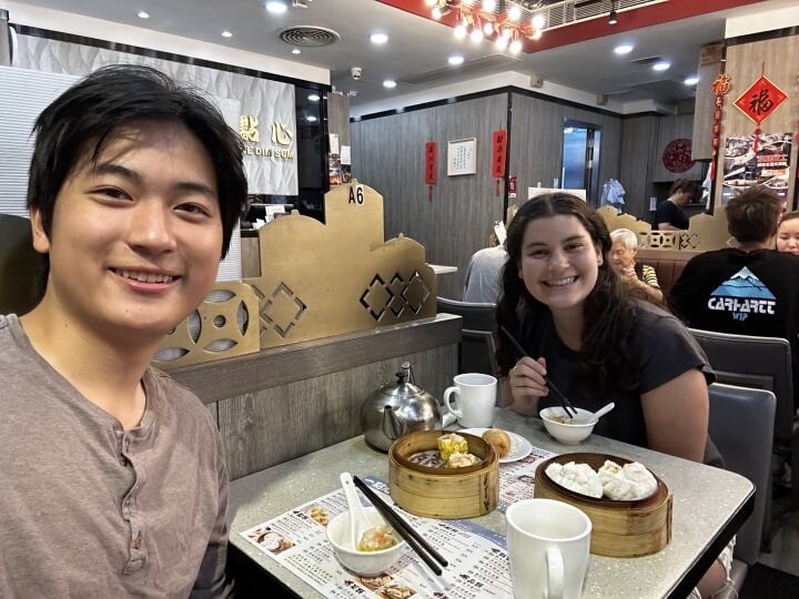 Two students eating dumplings at a restaurant in Hong Kong