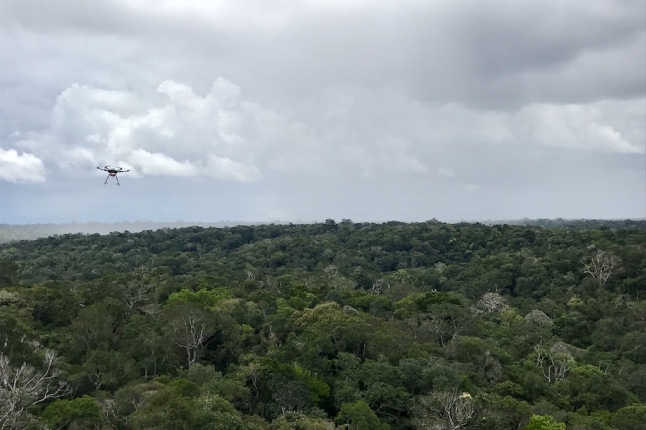 A drone flies towards a rain storm in the Amazon