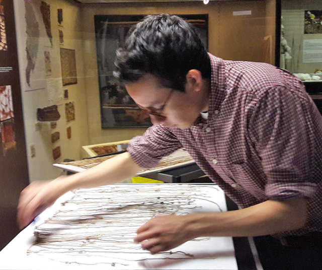 Medrano studies a khipu at the Lippisches Landesmuseum during a research trip to Detmold, Germany. (Photo courtesy of Manny Medrano.)